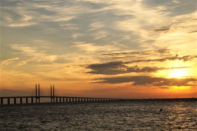 Naplemente a víz felett, kirajzolódva egy hosszú híd